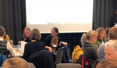 People sitting at tables at conference